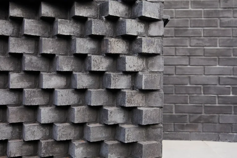 A textured brick wall on the left with an indented pattern stands beside a smoother one on the right, capturing the essence of North London's eclectic interior design, reminiscent of Highgate's charming architecture.